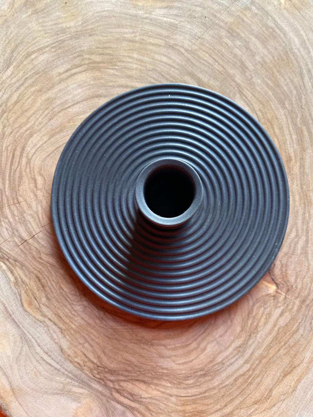 Ceramic nordic charcoal black candle holder on a wooden board