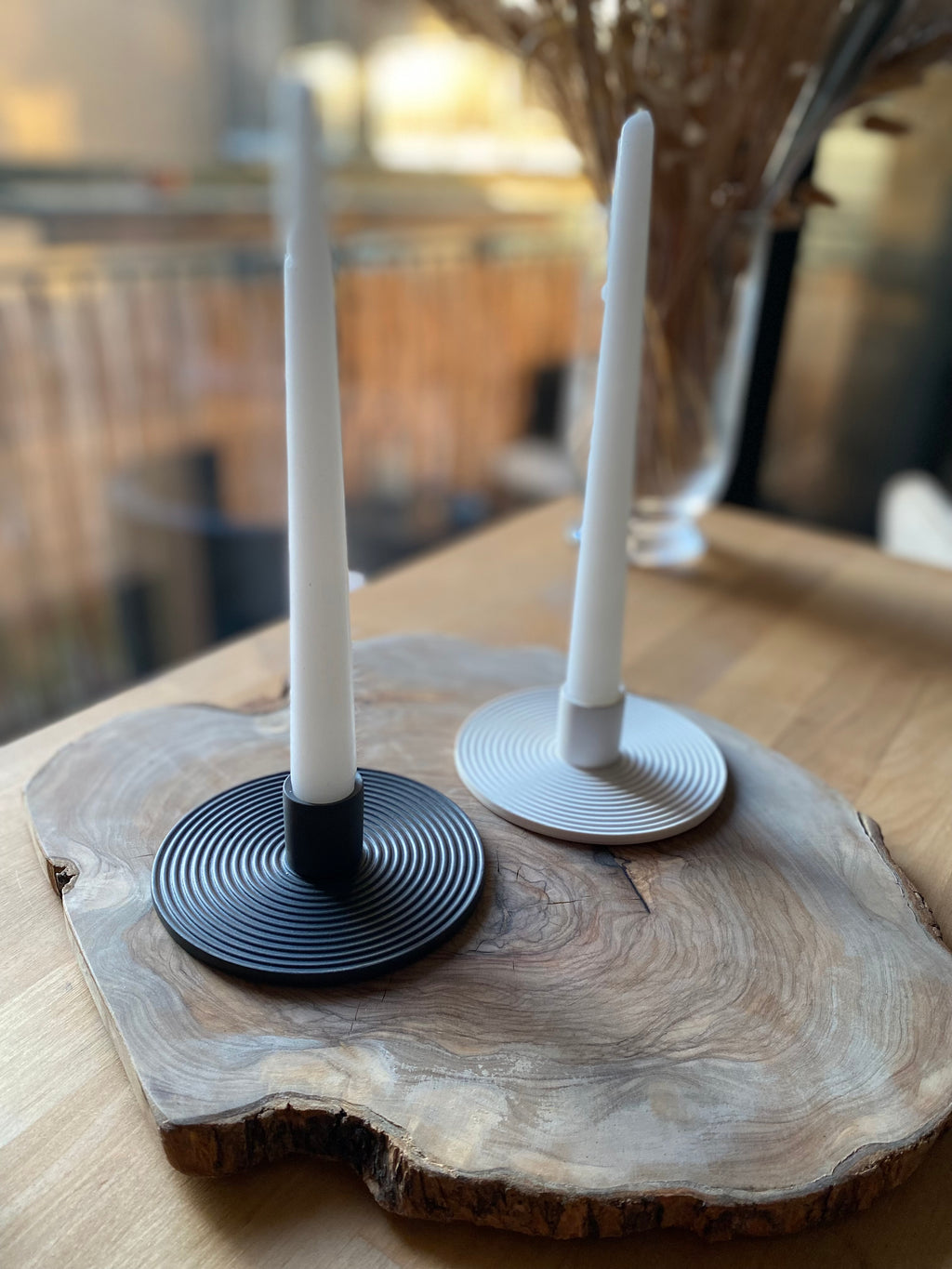 Two candle holders on a wooden surface with blurred background