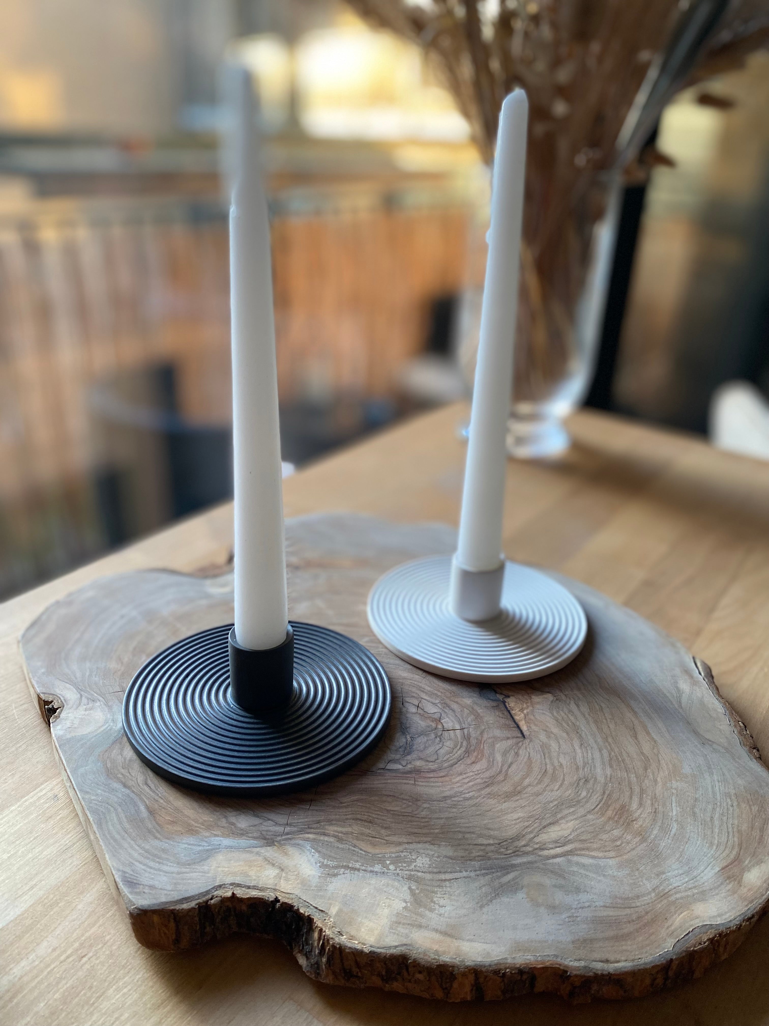 Two candle holders on a wooden surface with blurred background