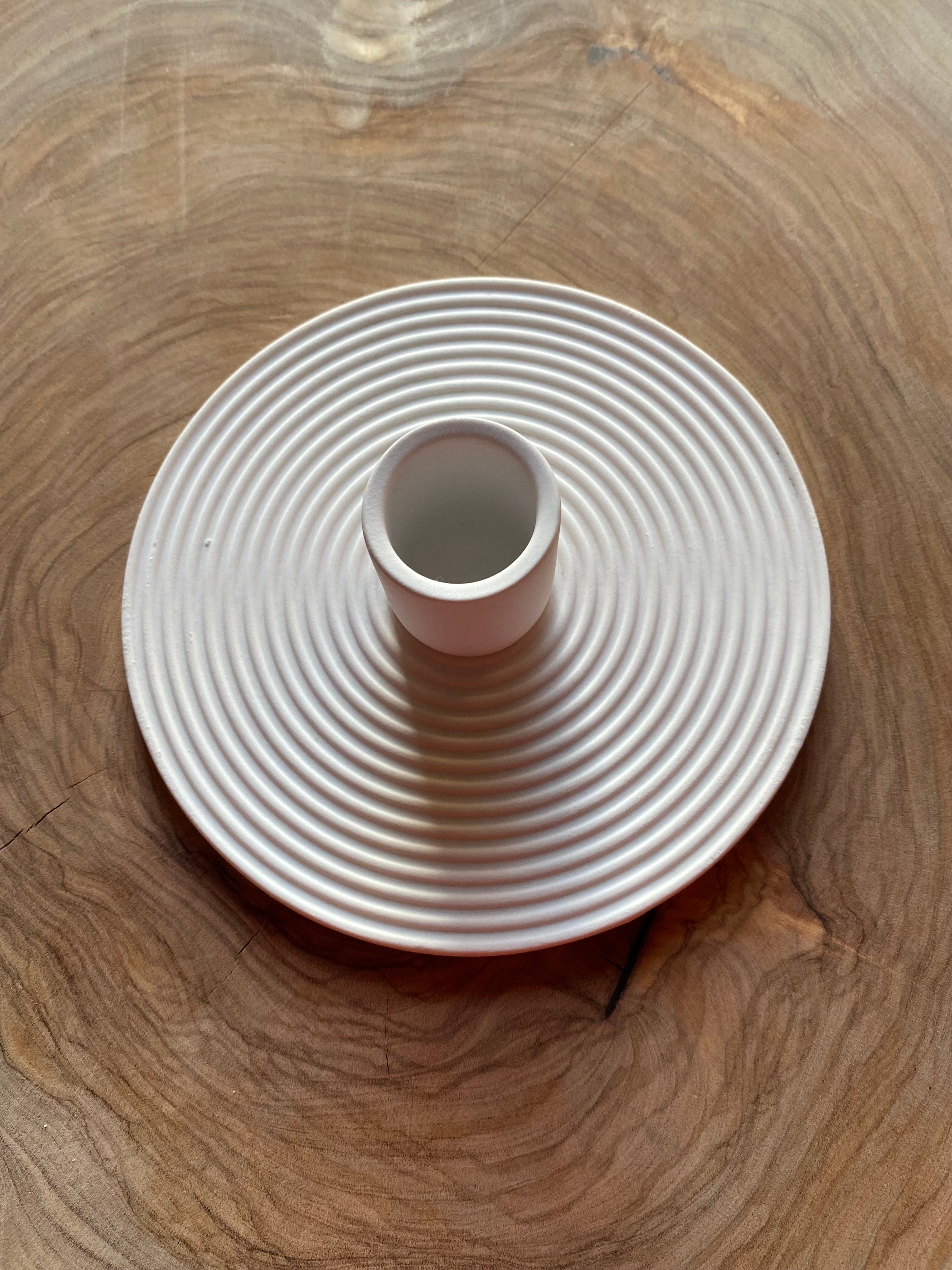 White textured candle holder on a wooden surface