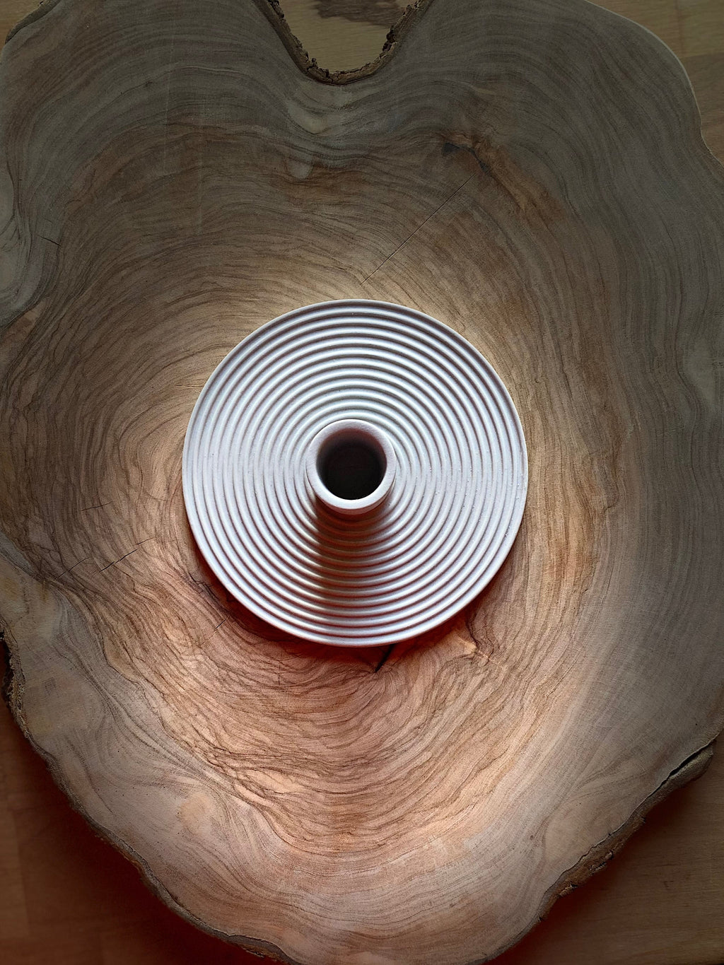 Grey ceramic candle holder on a wooden surface