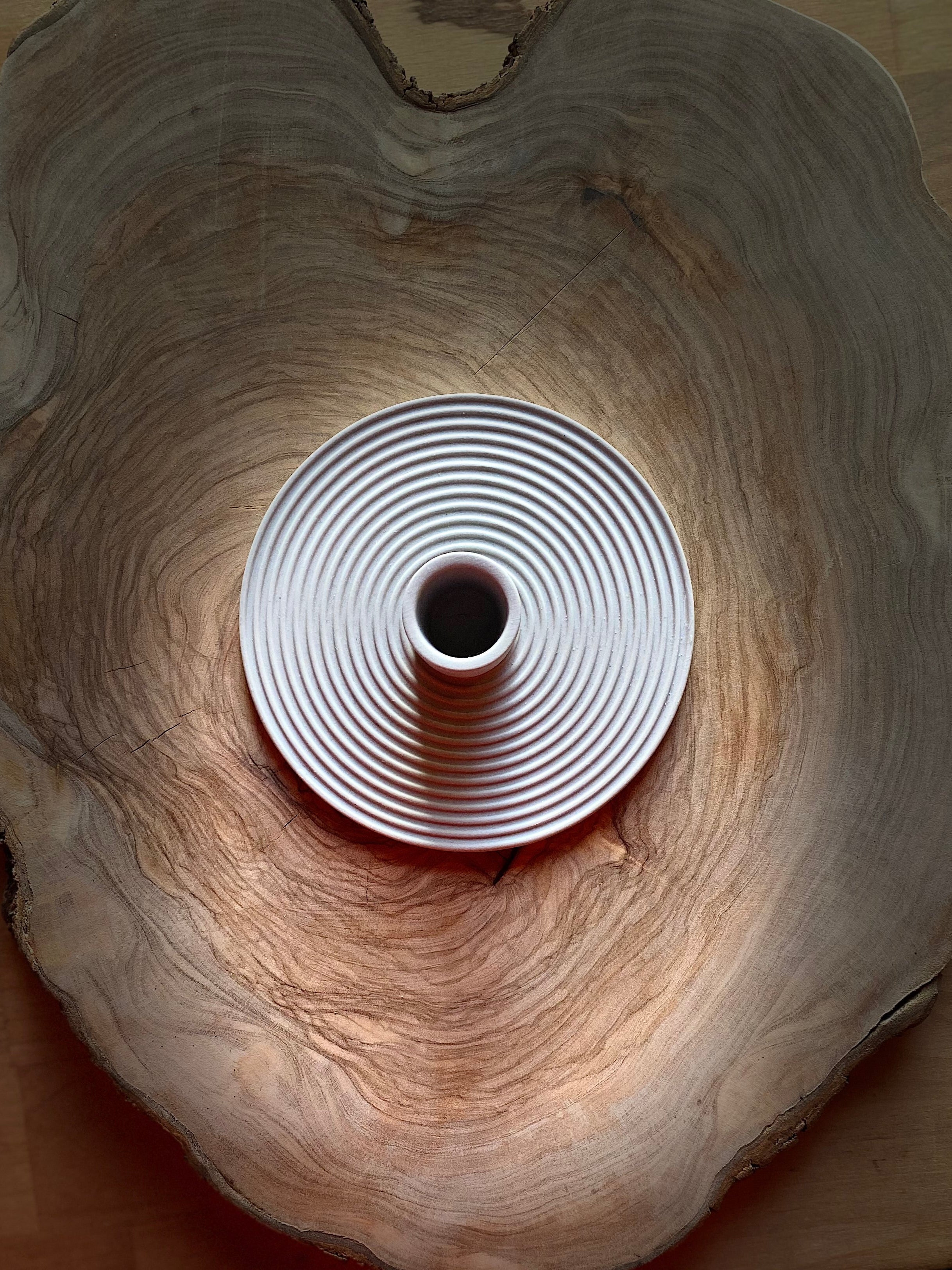 Grey ceramic candle holder on a wooden surface