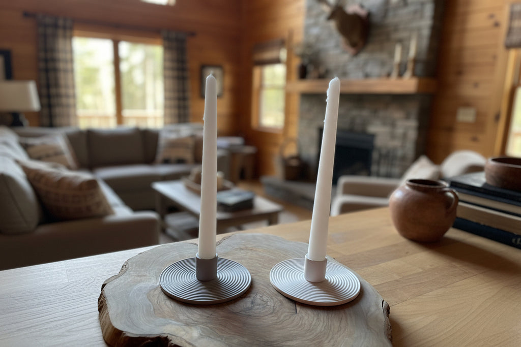 Two candle holders with white candles on a wooden surface